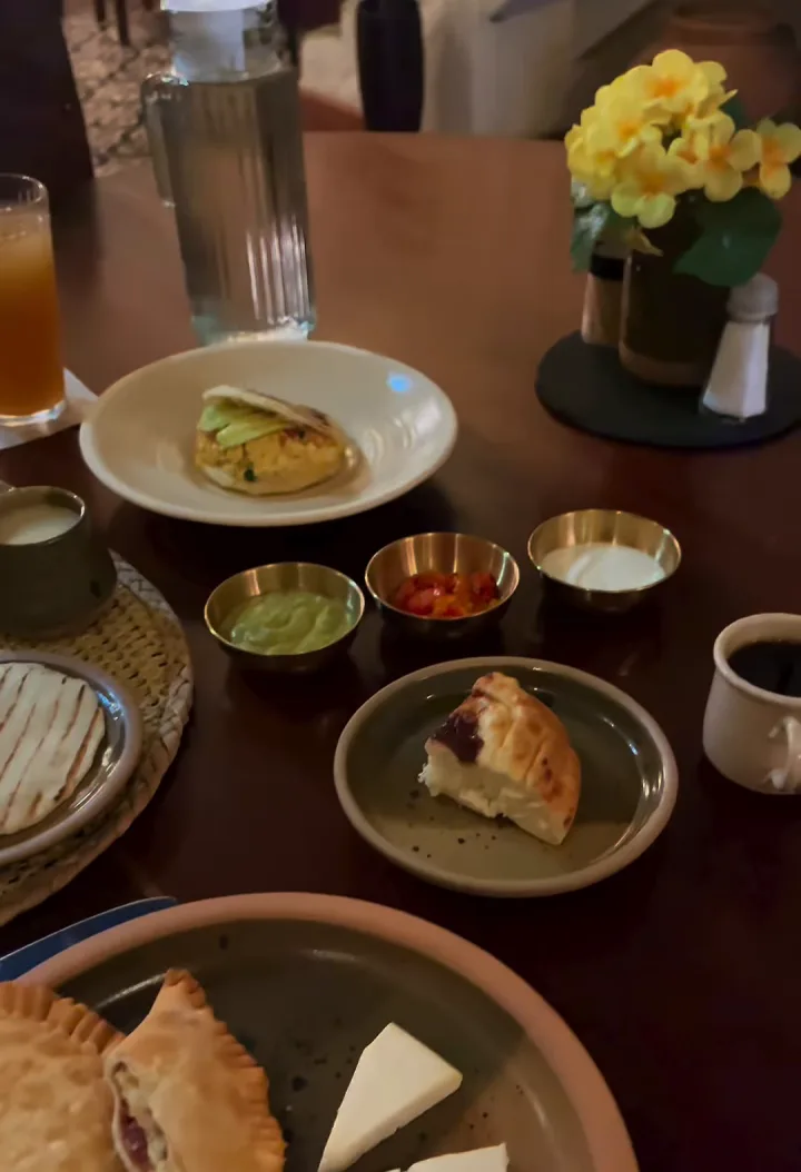 Mesa de desayuno con arepa, huevos en cazuela y bebidas