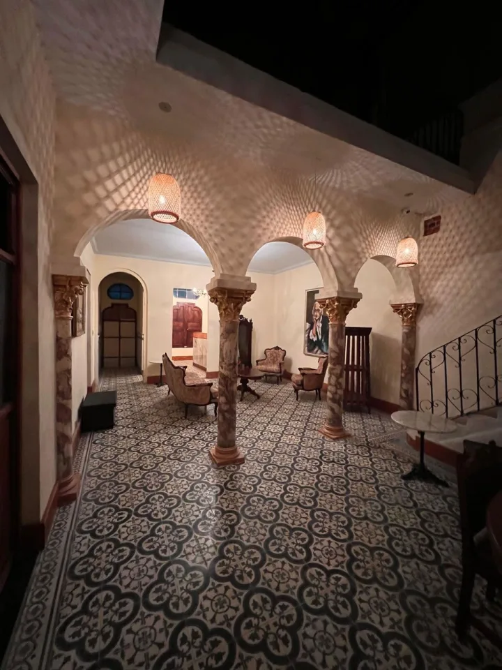 Patio interior de noche, con arcos e iluminación cálida