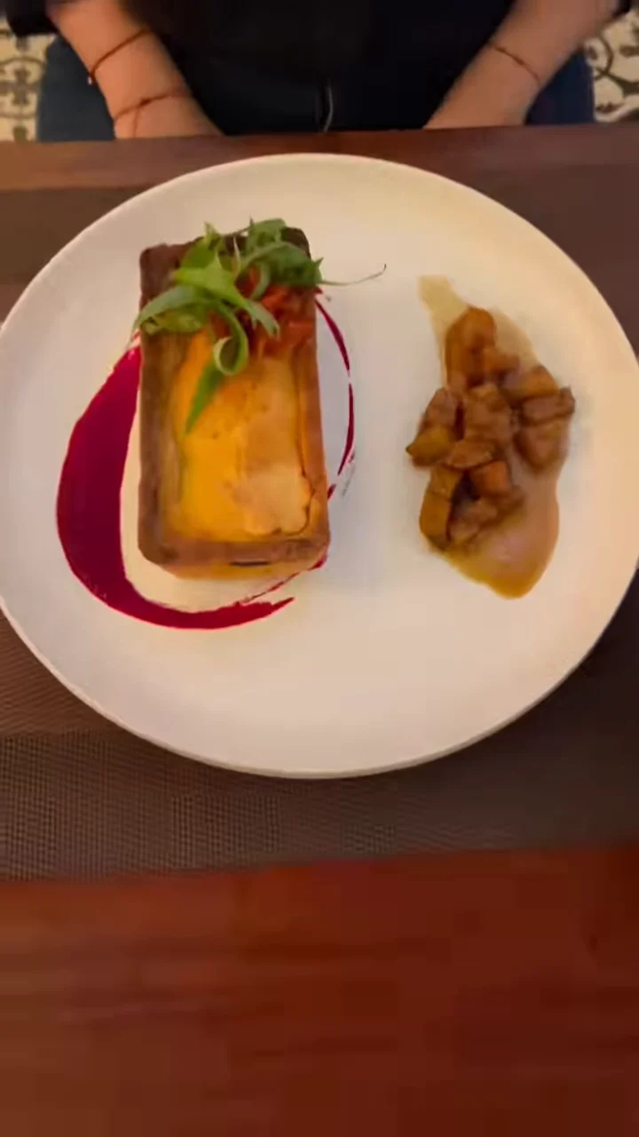 Polvorosa de pollo dorada sobre un plato blanco, con salsa rosada y guarnición